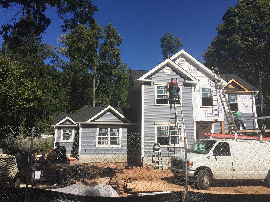 Residential exterior work with siding and windows visible