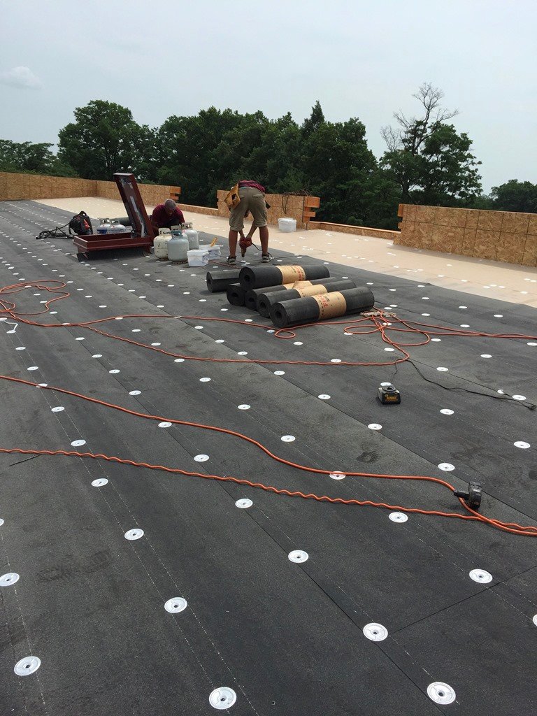 Roofing installation in progress on a low-slope roof