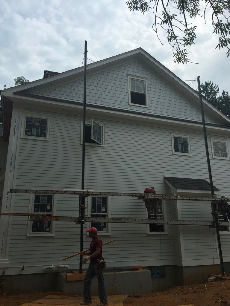 Siding and trim installation on a two-story house
